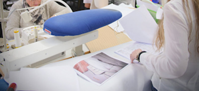 Fashion designers reviewing garment samples and documents in sewing studio