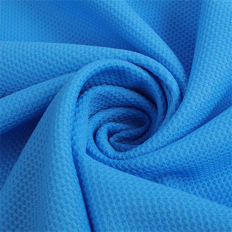 Close-up of blue textured sports fabric twisted to show breathable stretch mesh polyester