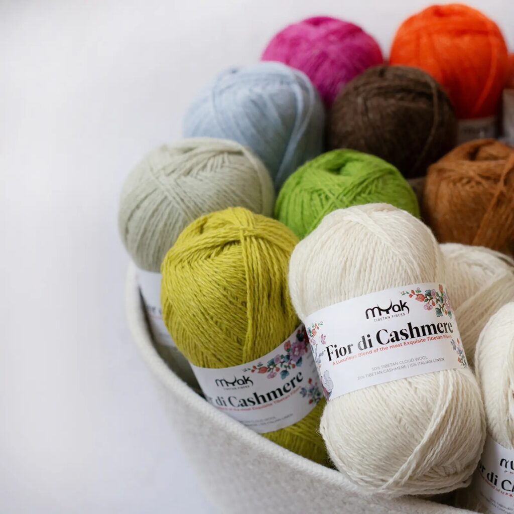Basket filled with colorful cashmere yarn skeins in soft vibrant shades