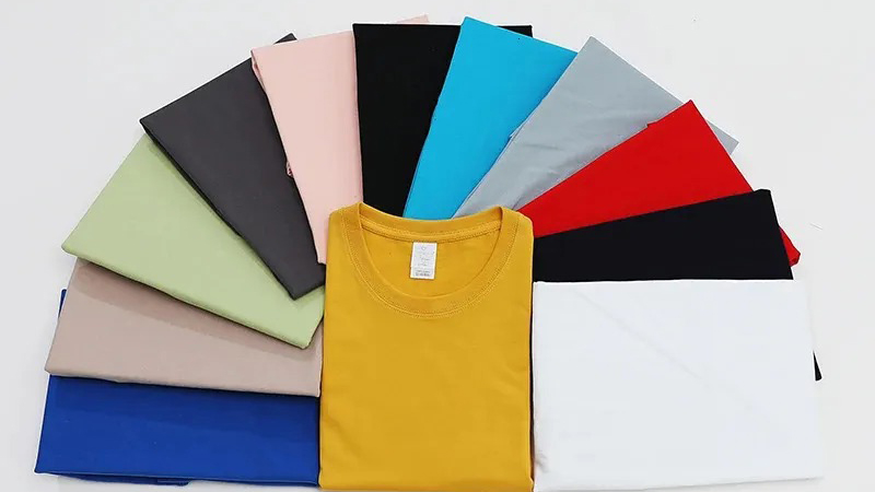 Colorful folded T-shirts and fabric panels arranged in fan shape on white background
