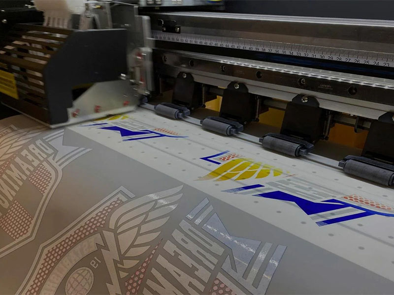 Large-format cutting machine trimming DTF file printed transfer sheets for garment decoration production