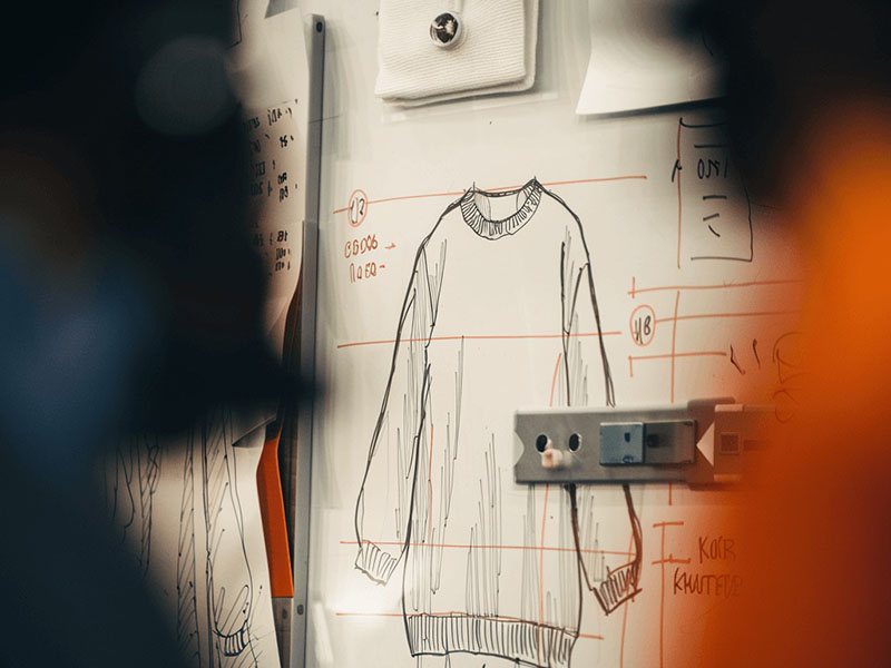 Sweater Fashion sketch of oversized sweater with measurement notes pinned on design board