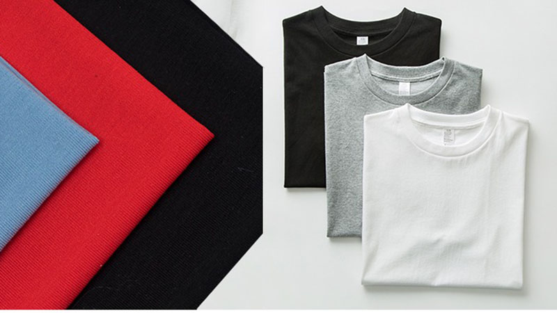Ribbed fabric swatches beside folded basic T-shirts in black, gray, and white
