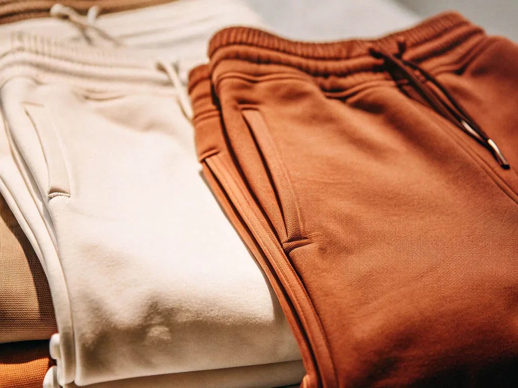Folded joggers in cream and rust tones with drawstring waist and side pockets.