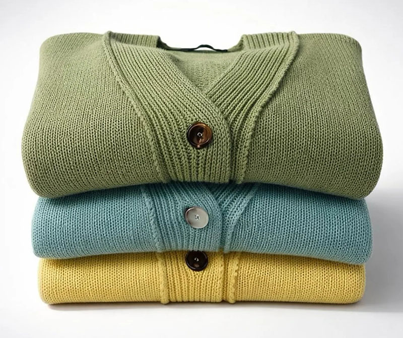 Three neatly folded cardigans stacked on top of each other