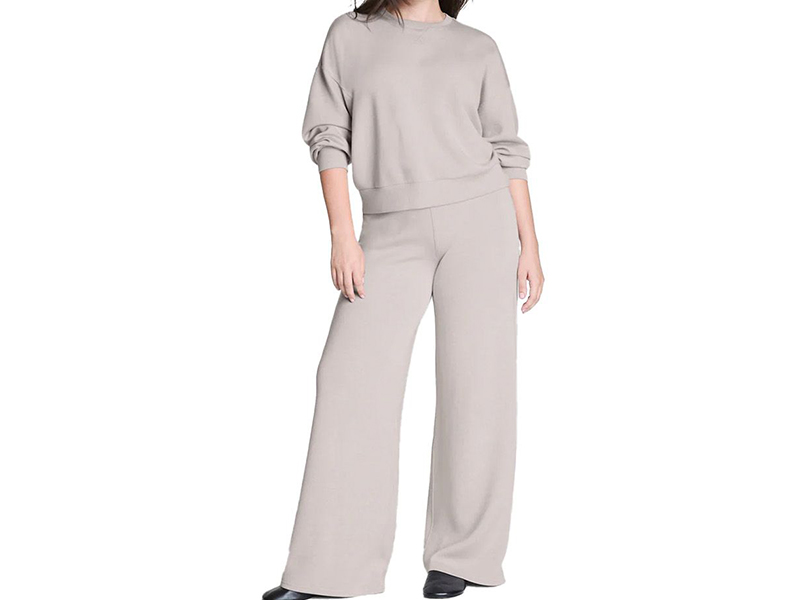 Woman wearing taupe lounge set with sweatshirt and wide-leg knit pants
