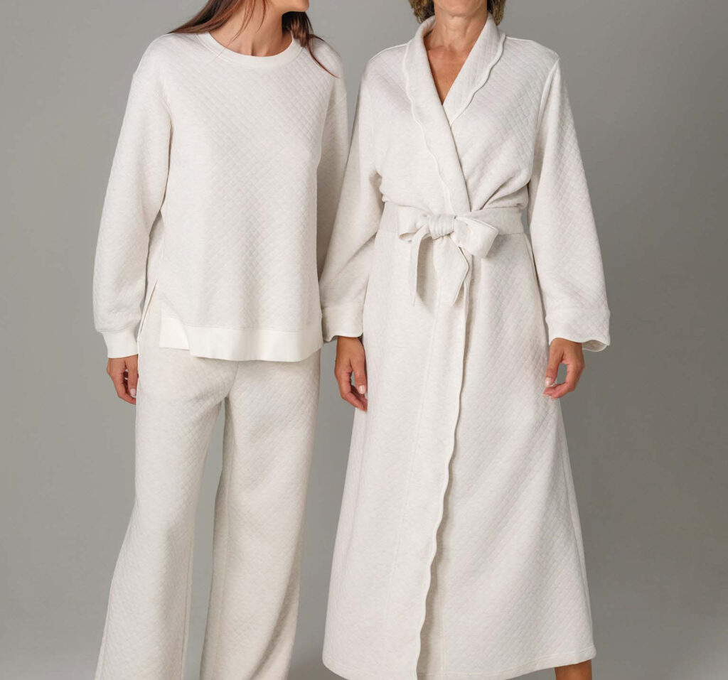 Two women wearing soft ivory quilted loungewear, including robe and set.