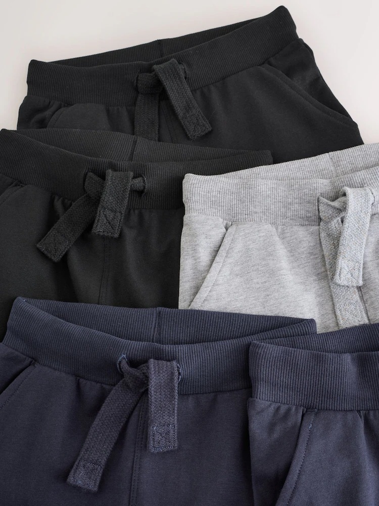 Assorted jogger pants in black, gray, and navy with drawstring waistbands.