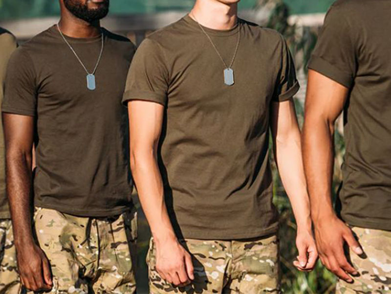 hree men standing outdoors wearing olive green T-shirts and camouflage pants