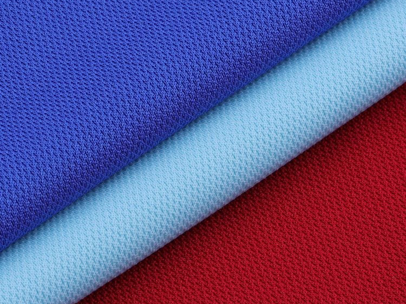 Blue, light blue, and red textured polyester  fabric layers stacked diagonally