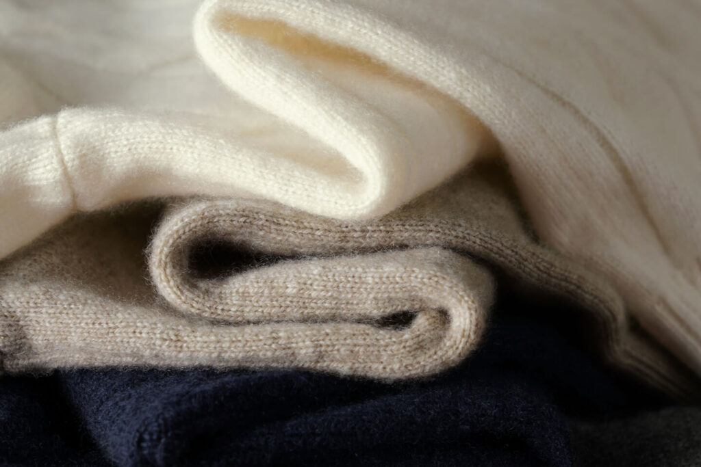 Close-up of three folded knit fabrics stacked together.