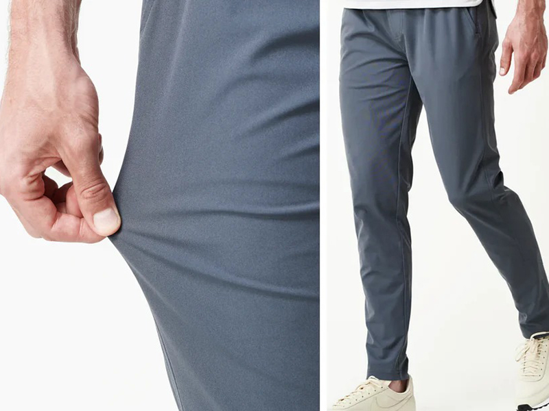 Close-up of gray performance joggers fabric being stretched beside slim-fit pants.