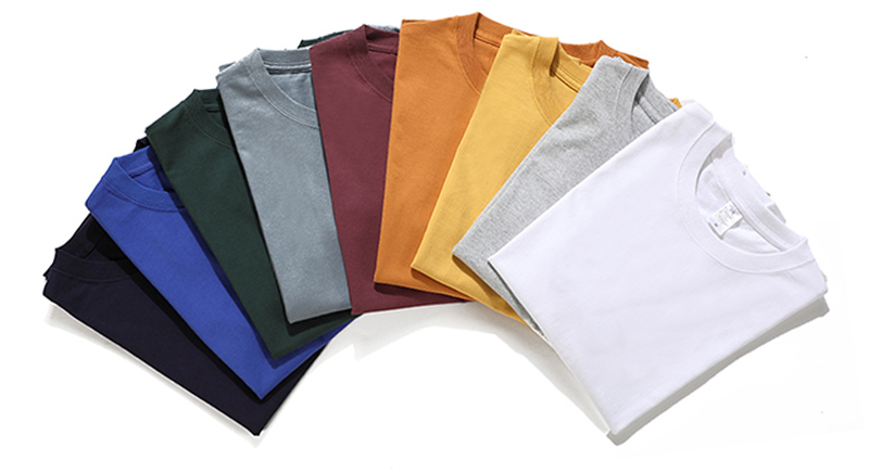Assorted folded plain T-shirts arranged in a fan shape with multiple colors