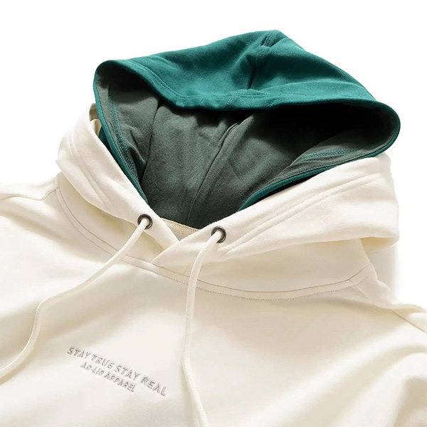 Cream hoodie with teal inner hood and white drawstrings shown in close-up