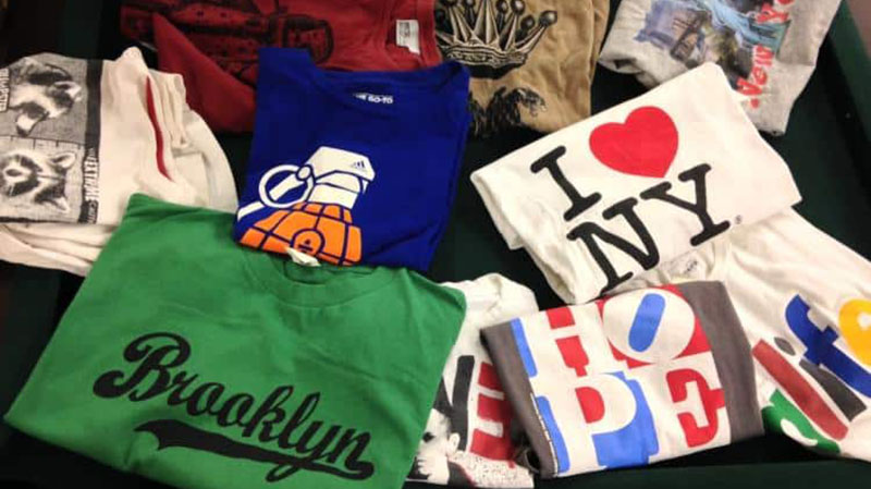 Assorted graphic T-shirts with bold prints and city-themed designs folded together