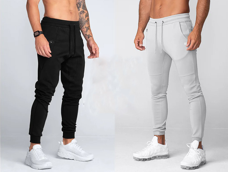 Men modeling slim athletic joggers in black and light gray with drawstring waists.