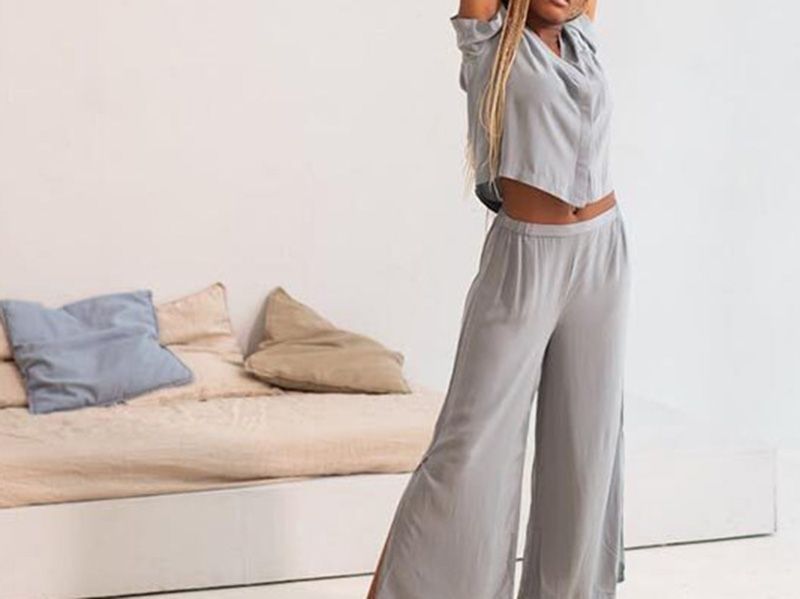 Woman wearing soft gray lounge set with cropped top and wide-leg pants.