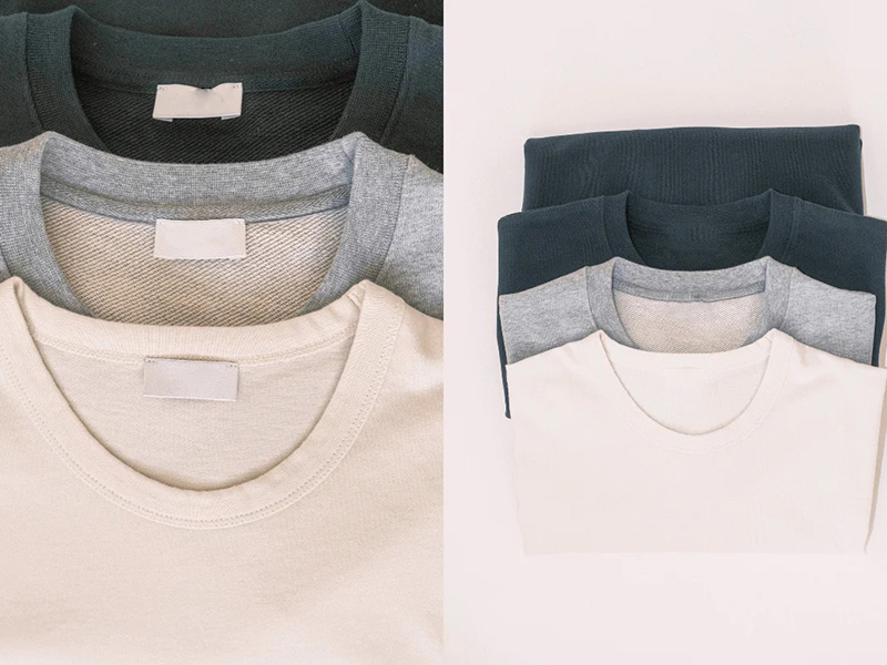 Folded crewneck sweatshirts in cream, gray, and dark green tones