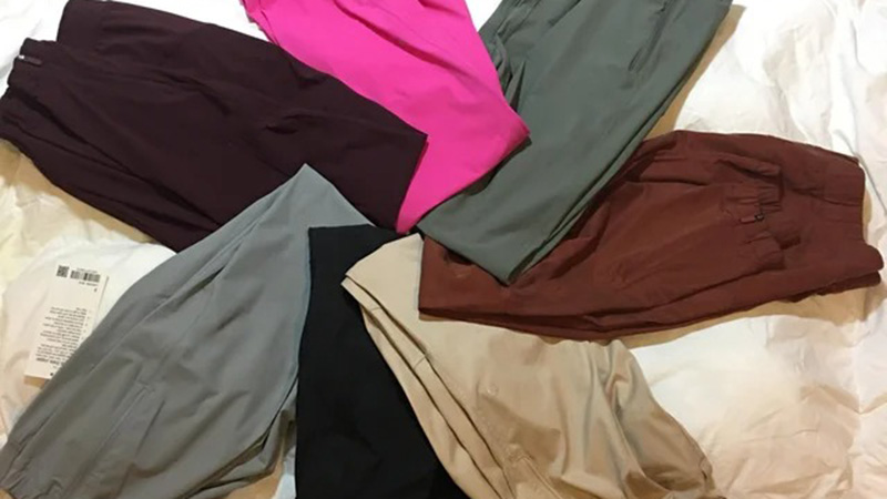 Assorted joggers pants laid flat in black, pink, olive, brown, gray, and beige colors.