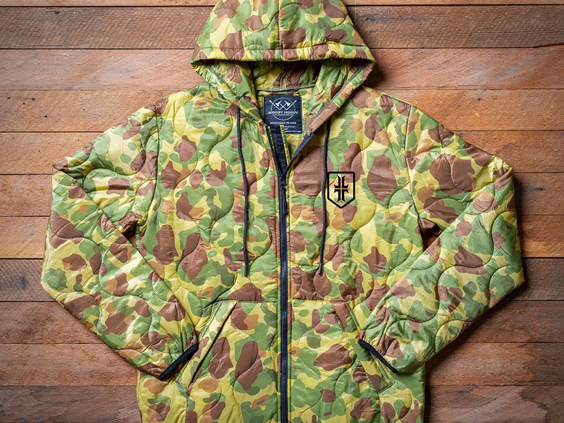 Camouflage quilted zip-up hoodie laid flat on a wooden surface