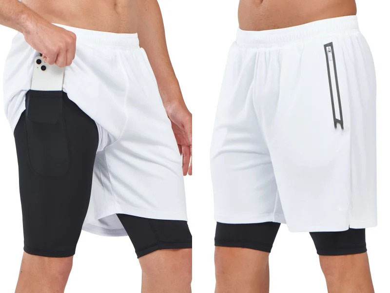 White men’s sports shorts with integrated black compression liner and side pocket holding a smartphone