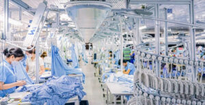 Modern garment factory with automated textile production and workers handling clothing assembly