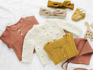 Cozy baby clothing set with knitted sweaters, headbands, socks, and soft cotton outfits