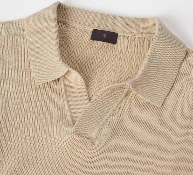 Close-up of beige Mercerized Cotton polo shirt with open collar and textured weave.