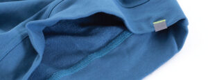 Close-up of blue French terry fabric showing soft looped interior and smooth outer knit texture for sweatshirt manufacturing