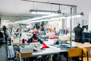 Garment workers sewing apparel in a busy textile and fashion production factory