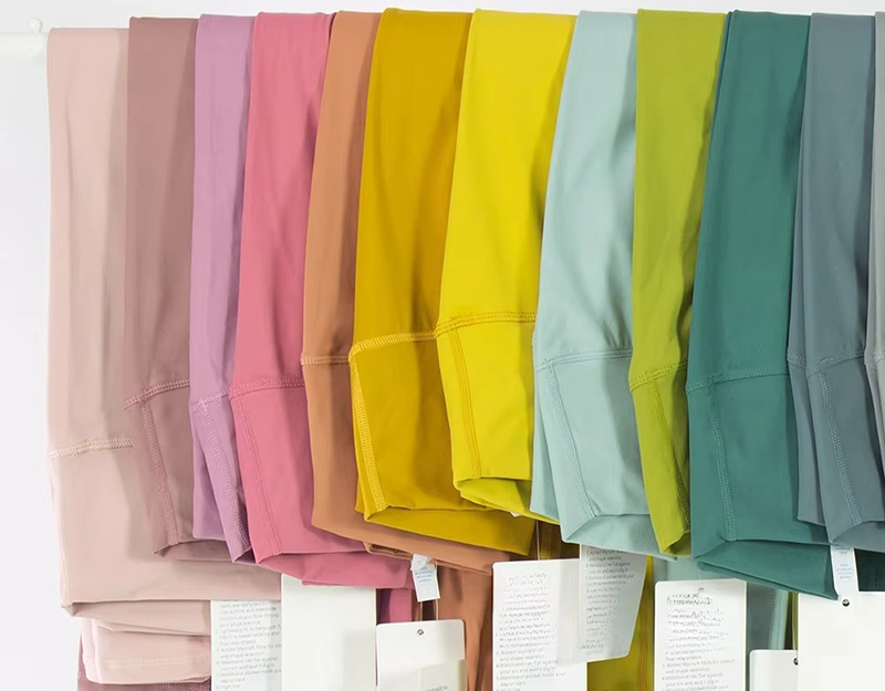 Colorful leggings hanging in pastel and bright shades including pink, yellow, green, and blue.