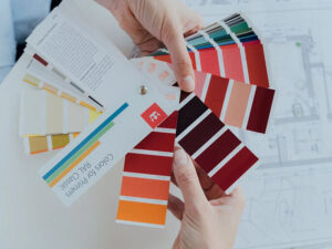 Hands holding colorful paint swatches for interior design and creative color matching