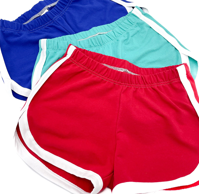 Three pairs of sporty shorts in red, teal, and blue, each with white trim along the sides and elastic waistbands.