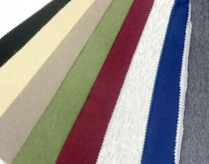 Multicolor fleece fabric swatches in black, beige, green, red, white, blue, and gray arranged side by side for textile selection and apparel manufacturing
