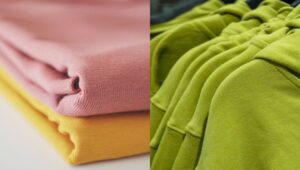 Folded pastel and green hoodie fabrics showcasing soft cotton texture and casual apparel material quality