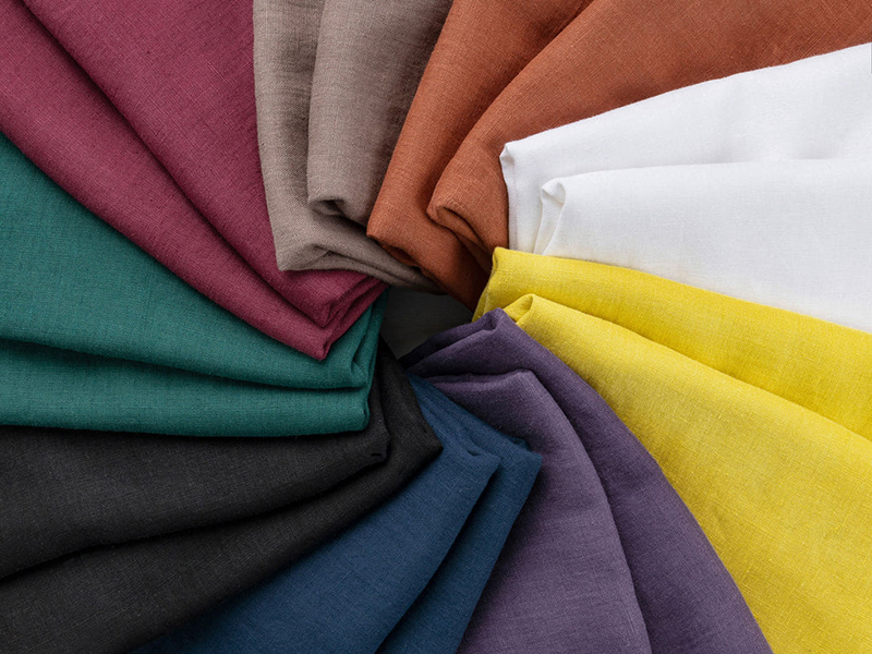 Vibrant linen fabric swatches arranged in colorful folded textile fan display
