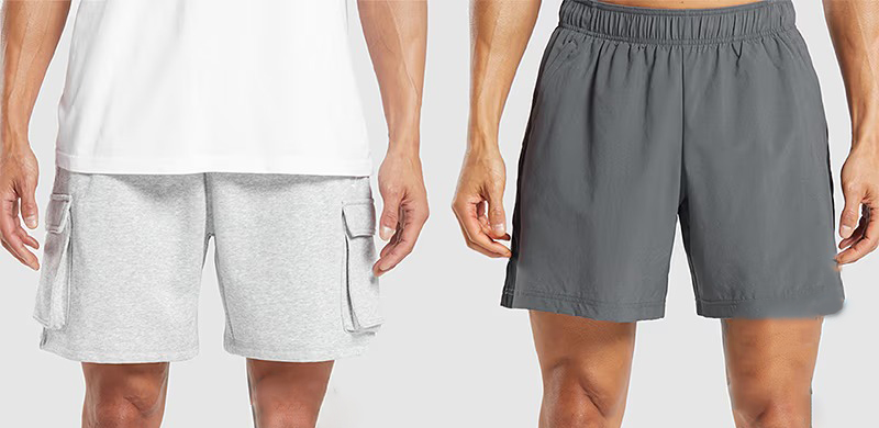 Two men standing side by side wearing shorts.