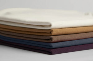 Neatly folded cotton fabric stack in neutral and pastel color shades