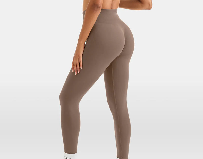 Woman wearing seamless high-waist sculpting leggings in neutral taupe color