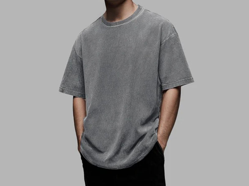 Man wearing oversized washed gray T-shirt with relaxed fit and vintage faded finish.