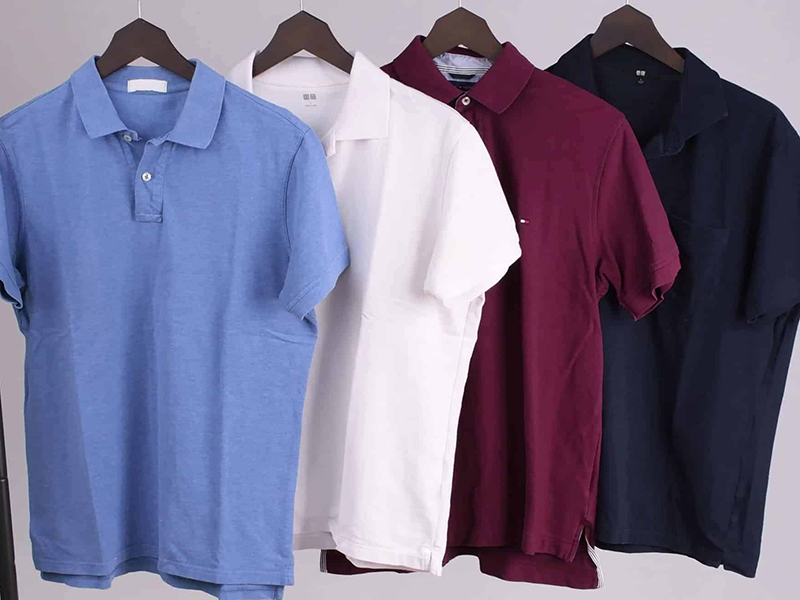 Four short-sleeve polo shirts hanging in light blue, white, burgundy, and navy colors.