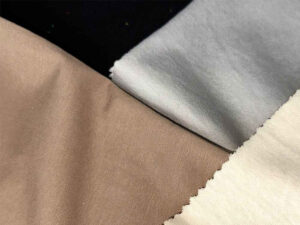 Close-up of beige, gray, and cream jersey knit fabric samples.