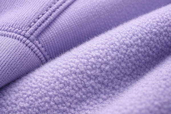 Close-up of lavender sweatshirt fabric showing soft fleece lining and smooth outer knit.