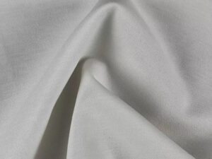 Close-up of soft light gray interlock cotton fabric with subtle texture folds.