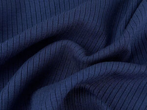 Dark navy rib knit fabric with textured stretch pattern and soft folded drape for activewear and fashion apparel manufacturing