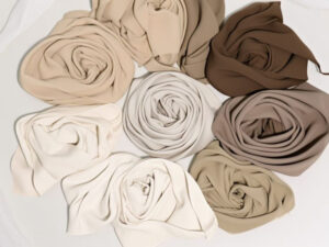 Rolled neutral tone fabrics in beige, cream, and brown shades for fashion design