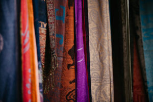 Colorful patterned scarves hanging vertically with intricate textile designs and rich fabric textures
