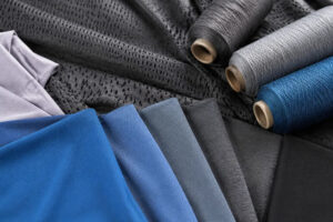 Colorful athletic fabric samples and yarn spools for activewear textile sourcing