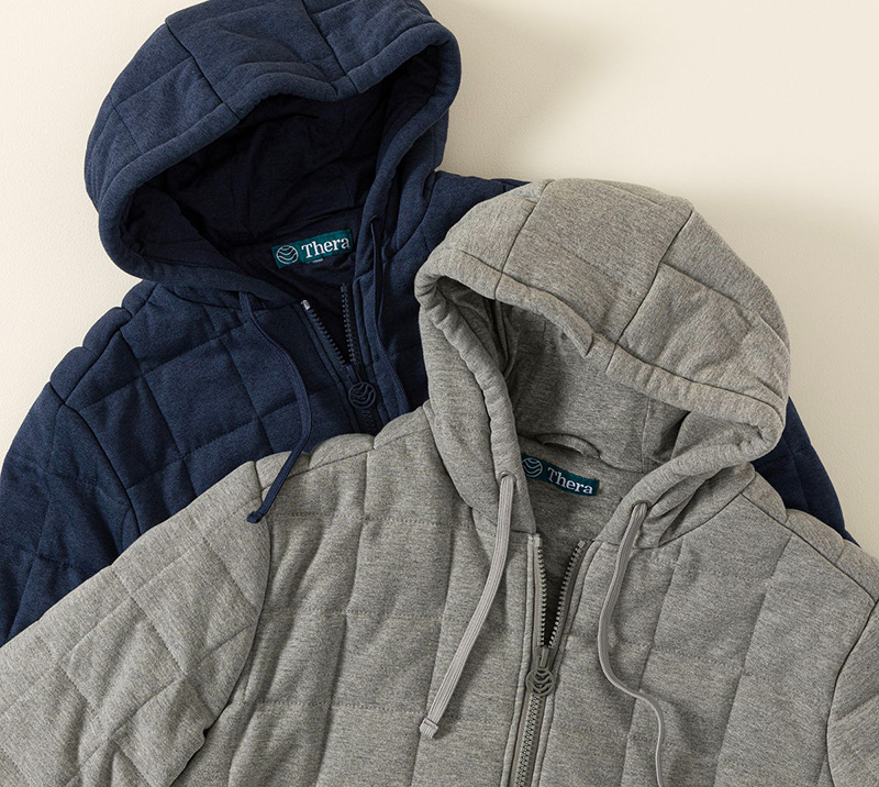 Two quilted zip-up Weighted hoodies in navy and gray layered together on display.