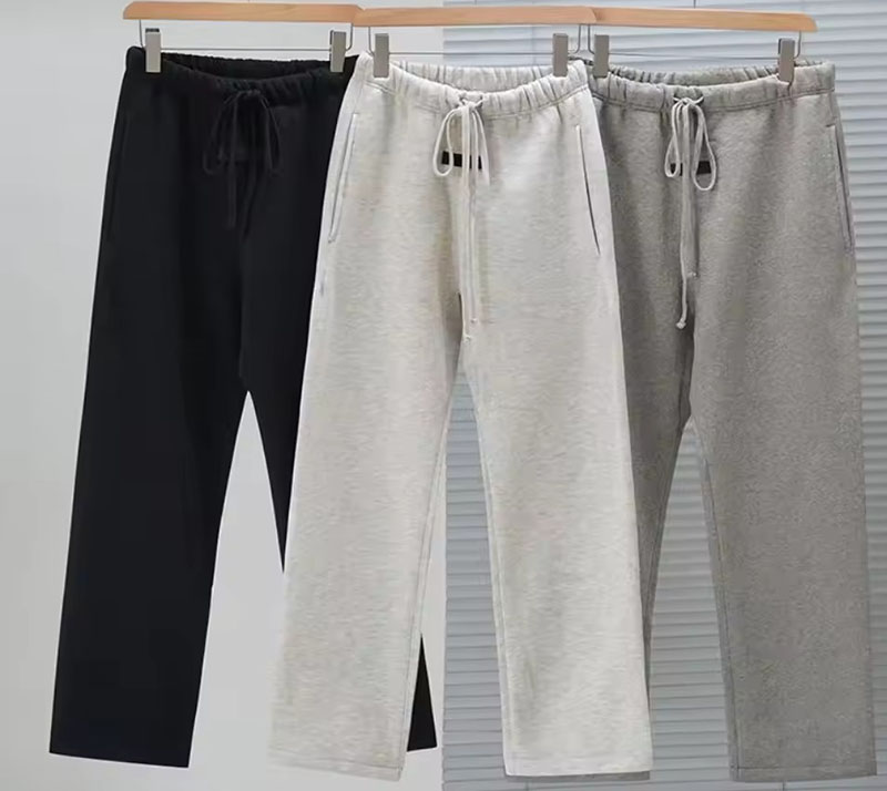 Cozy drawstring sweatpants in black, white, and gray hanging on rack
